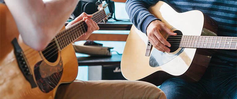 two people testing out guitars