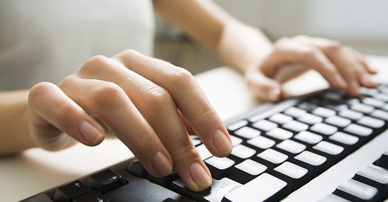 Woman typing on a keyboard
